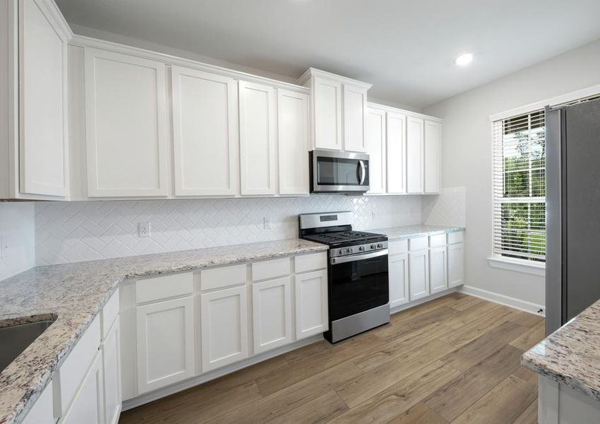 Kitchen with white cabinets and white ceramic backsplash