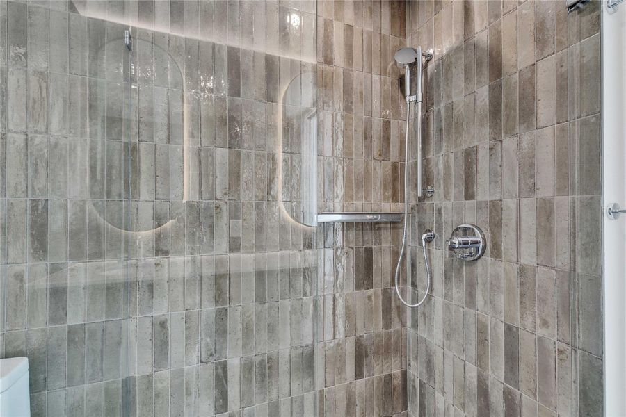 Glazed vertical tiling creates a modern, textured backdrop in this walk-in shower. Glazed vertical tiling creates a modern, textured backdrop in this walk-in shower.