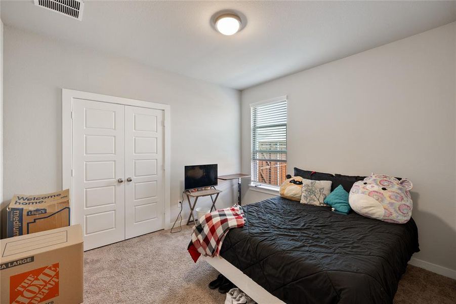 Carpeted bedroom with a closet