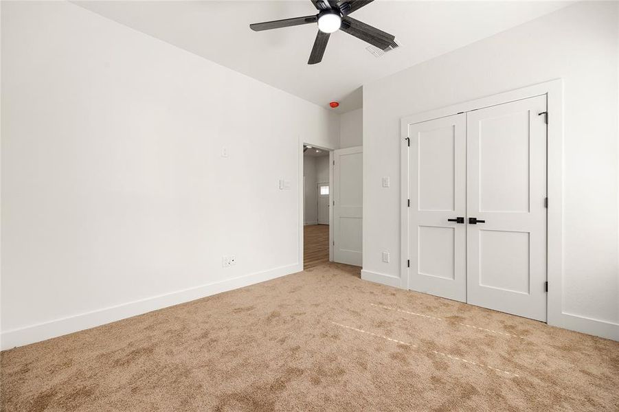 Comfortable Secondary BedroomThis inviting bedroom features a spacious double-door closet, plush carpeting, and a sleek ceiling fan. With a neutral color palette and natural light, this room offers a cozy and versatile space for any need!