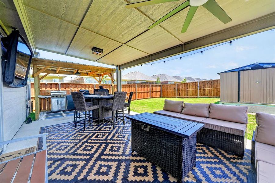 Covered patio featuring an outdoor ceiling fan and string lighting