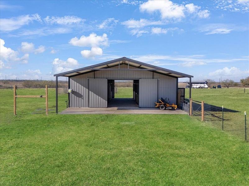 View of pole building featuring a view of countryside and a lawn