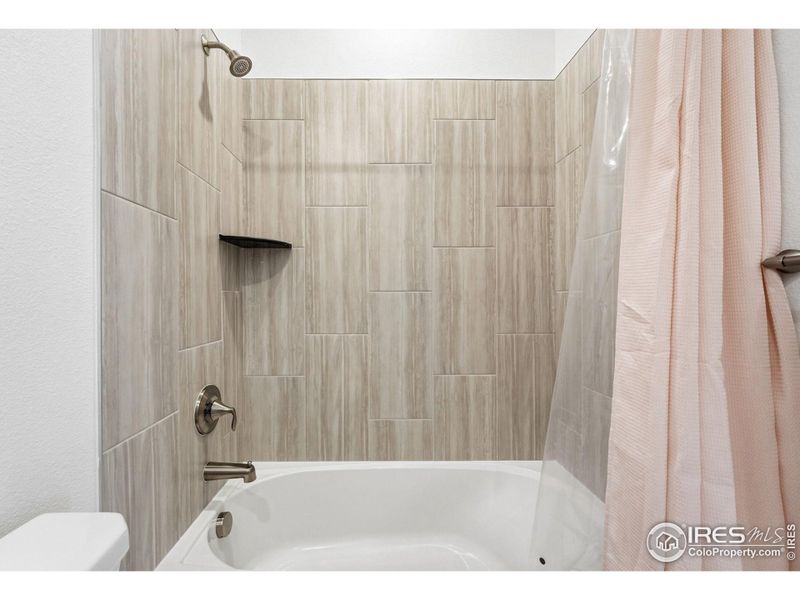 Alternate bathroom view highlighting clean tile and thoughtful finishes.