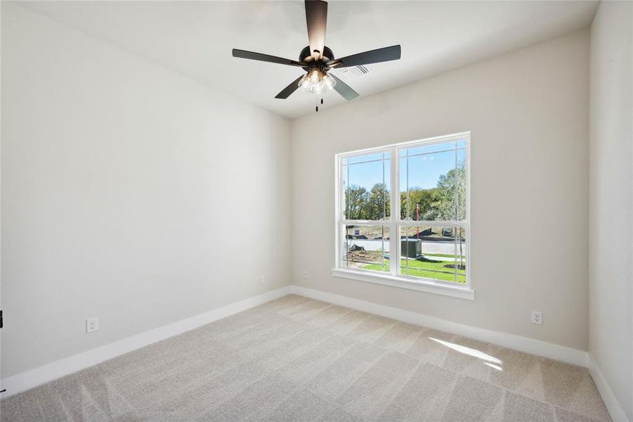 Spare room with ceiling fan and light carpet