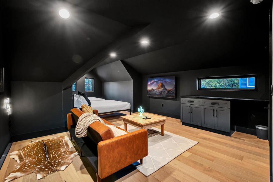 Home theater with light wood-style flooring, vaulted ceiling, and recessed lighting Home theater with light wood-style flooring, vaulted ceiling, and recessed lighting