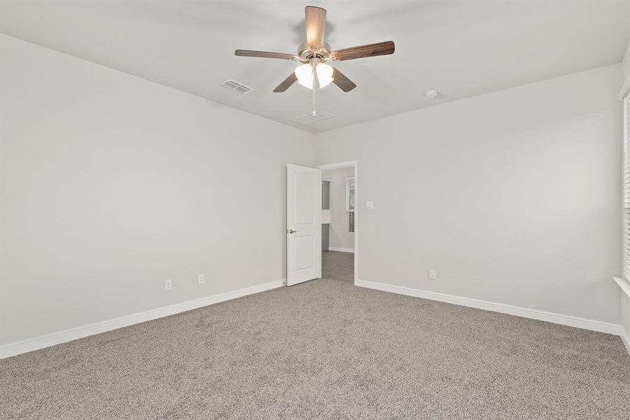 Unfurnished room with ceiling fan and carpet