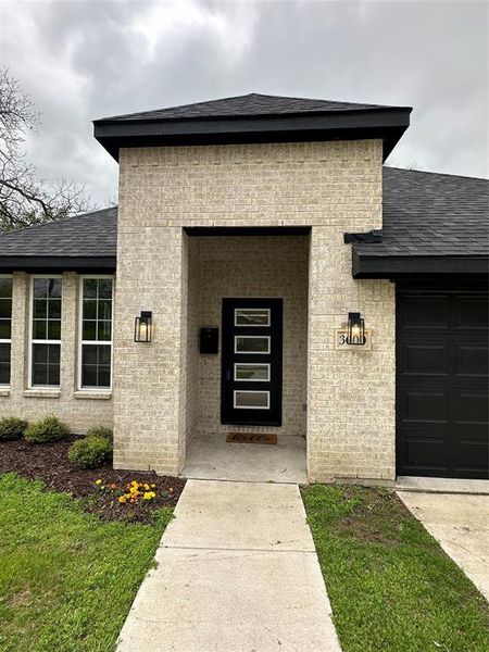 View of exterior entry featuring an attached garage and roof with shingles View of exterior entry featuring an attached garage and roof with shingles