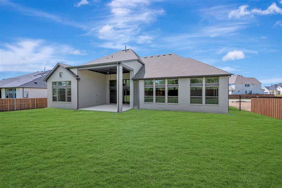 Rear view of house featuring a patio area, a fenced backyard, a shingled roof, and stucco siding