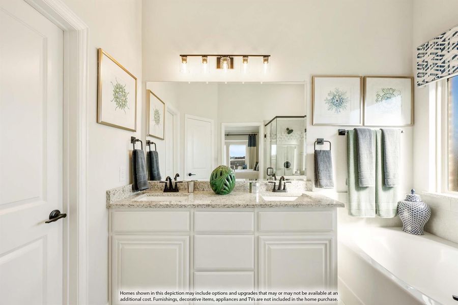 Bathroom with double vanity, white cabinets, granite countertops, large mirror, and soaking tub