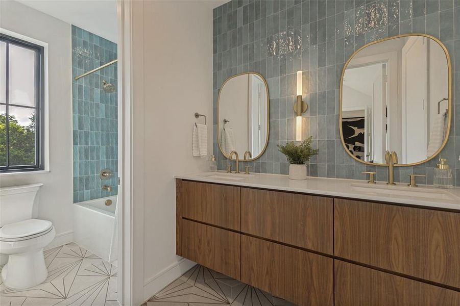 Bathroom featuring a double vanity with wood-finish cabinetry, a white countertop, and gold-tone fixtures Bathroom featuring a double vanity with wood-finish cabinetry, a white countertop, and gold-tone fixtures