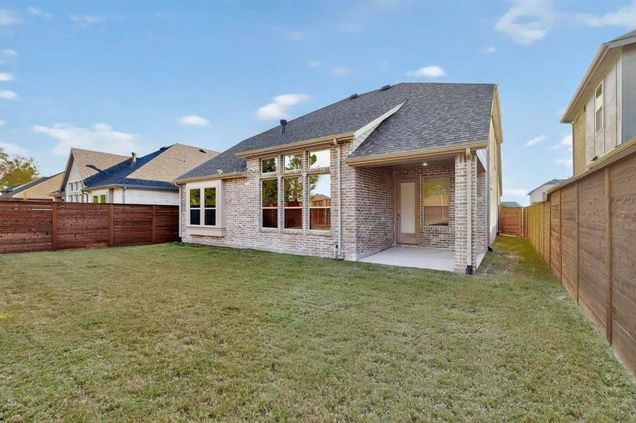 Rear view of property with a patio area, roof with shingles, brick siding, and a fenced backyard Rear view of property with a patio area, roof with shingles, brick siding, and a fenced backyard