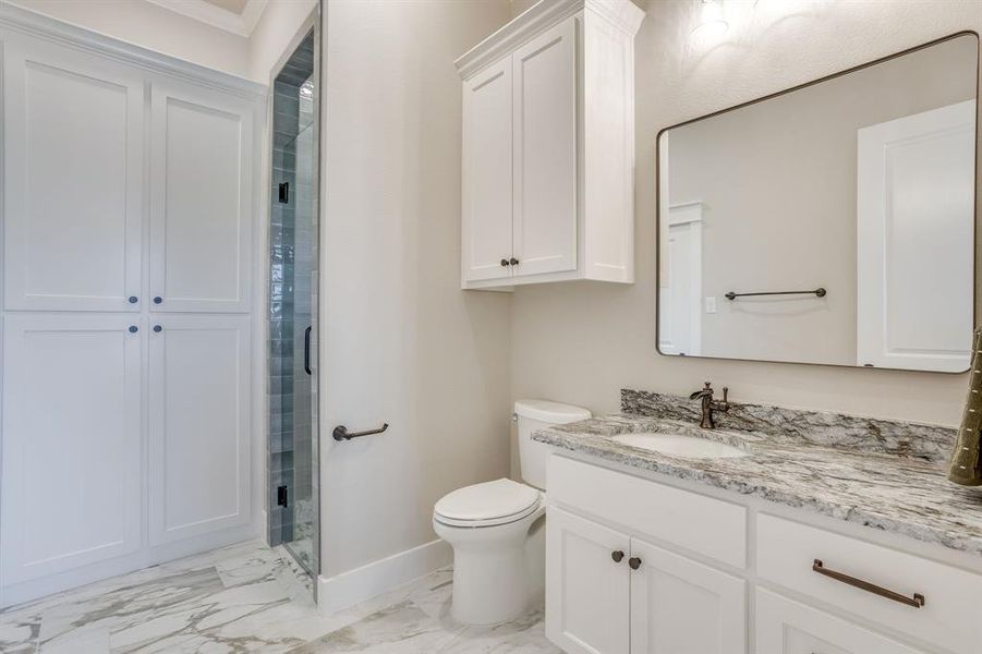 Bathroom featuring a vanity with a white cabinet and a light-toned, veined countertop