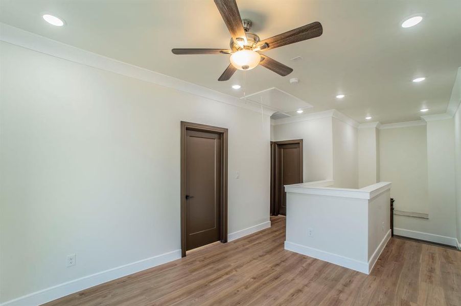 Empty room featuring attic access, recessed lighting, wood finished floors, ornamental molding, and a ceiling fan Empty room featuring attic access, recessed lighting, wood finished floors, ornamental molding, and a ceiling fan