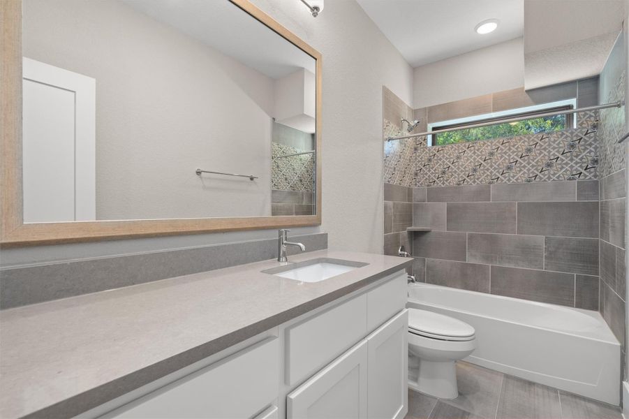 A well-appointed bathroom features a single vanity, a sleek toilet, and a combination shower-tub. A well-appointed bathroom features a single vanity, a sleek toilet, and a combination shower-tub.