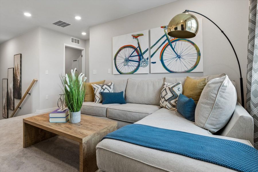 A living room with a couch and a bike on the wall. A living room with a couch and a bike on the wall.