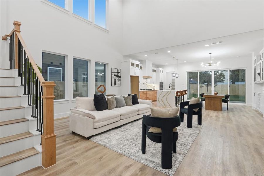 Living room with light wood-type flooring and hanging lights