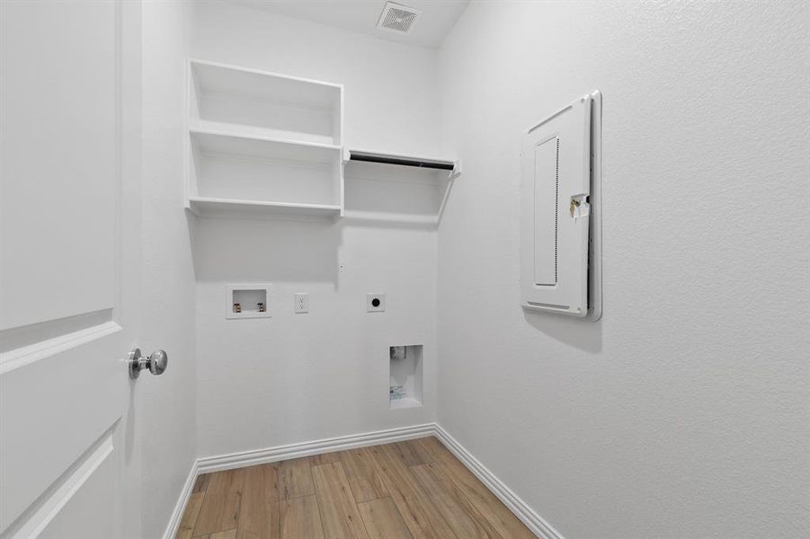 Washroom with hookup for an electric dryer, wood-type flooring, and hookup for a washing machine