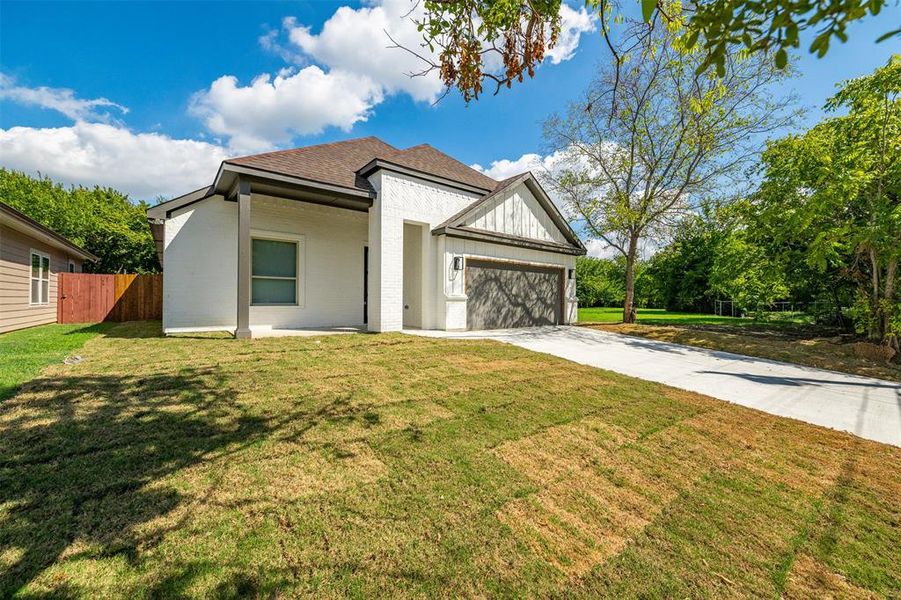 View of front of house featuring a front lawn and a garage