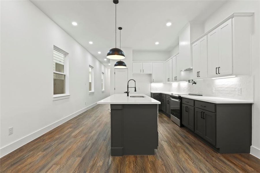 Kitchen with white cabinetry, a kitchen island with sink, pendant lighting, stainless steel range with electric stovetop, and dark wood finished floors