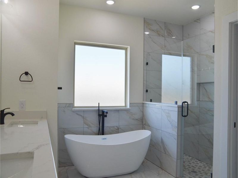 Bathroom featuring vanity and separate shower and tub