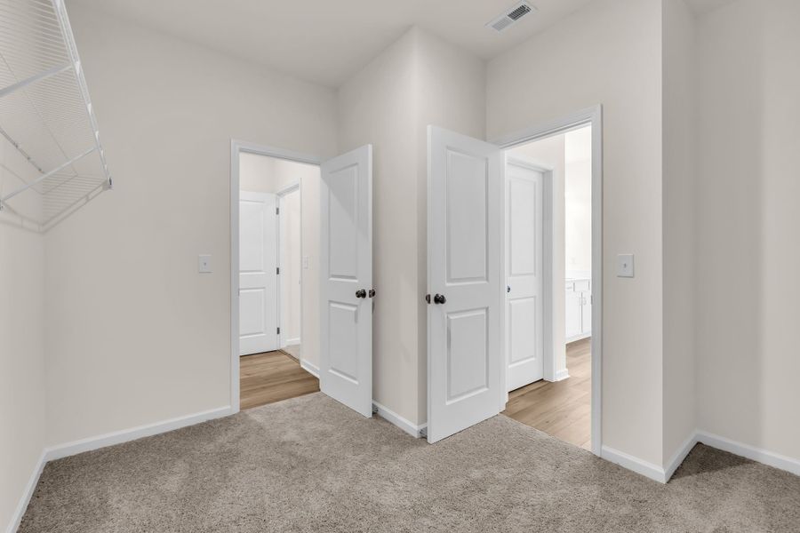 Large walk-in closet with access to your laundry room (left) and primary en suite bathroom (right). Large walk-in closet with access to your laundry room (left) and primary en suite bathroom (right).