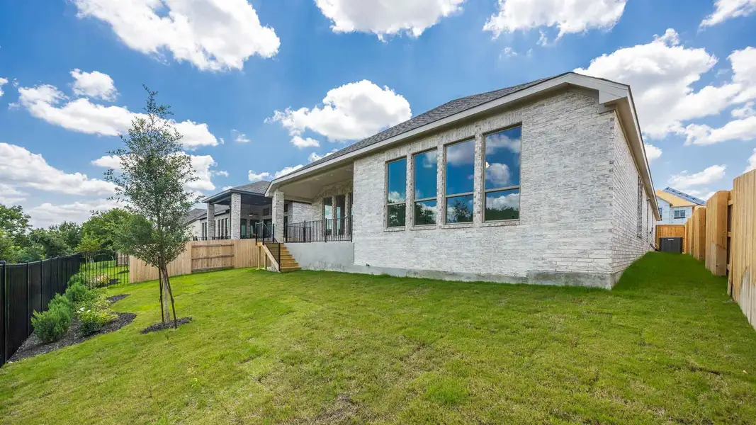 Rear view of property with a fenced backyard, stairs, and brick siding Rear view of property with a fenced backyard, stairs, and brick siding