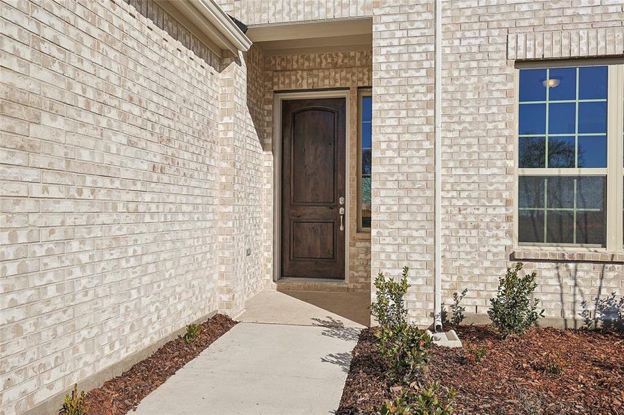 View of exterior entry with brick siding