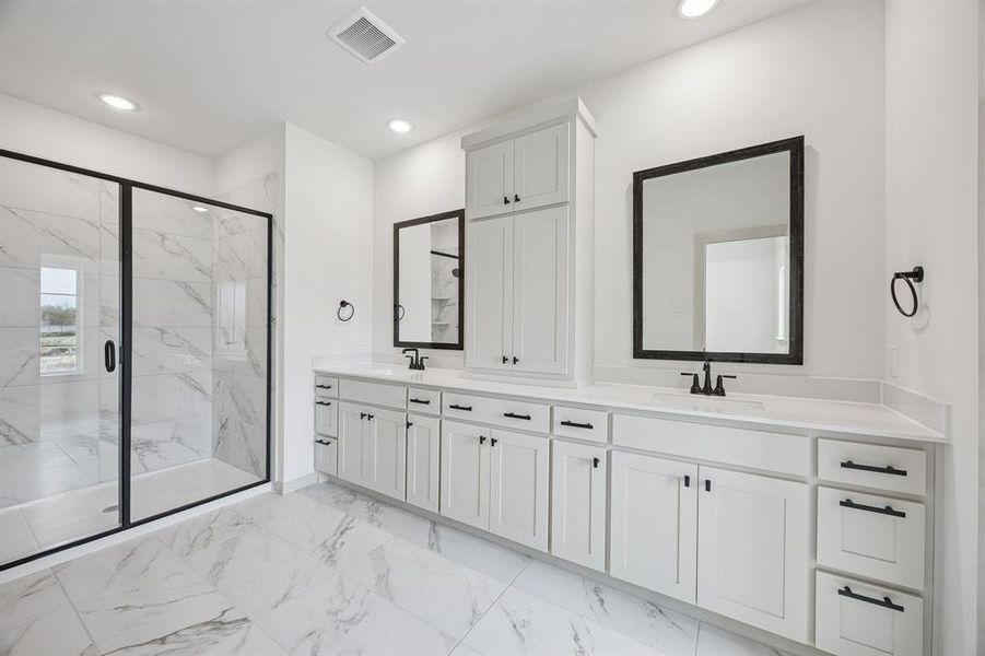 Featuring a clean, crisp white color palette with striking dark accents, this dream owner's bath offers plenty of room for two!