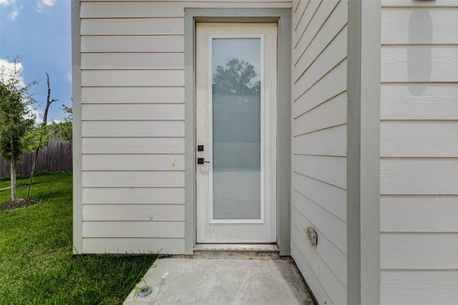 The side-entry perspective showcases the home’s contemporary siding, tall window detail, and clean exterior finish. This angle reinforces the newer construction feel and streamlined design of the property.