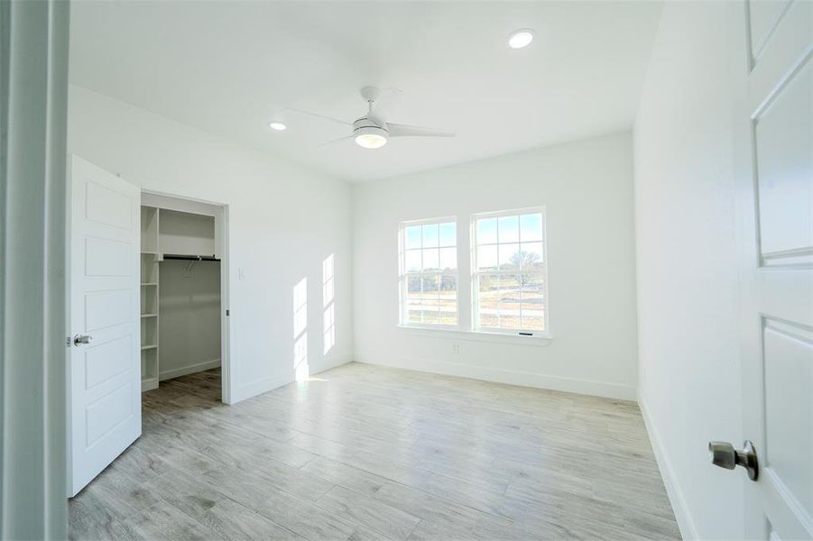 Bedroom (2) Unfurnished bedroom with recessed lighting, light wood-style flooring, a walk in closet, and a ceiling fan Bedroom (2) Unfurnished bedroom with recessed lighting, light wood-style flooring, a walk in closet, and a ceiling fan
