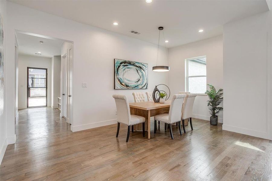 Dining area featuring baseboards, light wood finished floors, visible vents, and recessed lighting