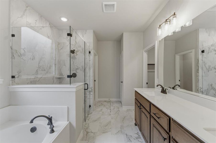 Bathroom featuring a glass-enclosed shower with white marble-style tile surround, a soaking tub with dark bronze-finish fixtures, a dual-sink vanity with white countertop, and dark bronze-finish hardware