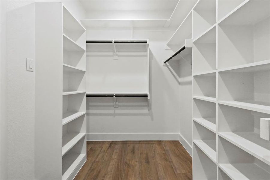 Walk in closet featuring dark wood finished floors Walk in closet featuring dark wood finished floors
