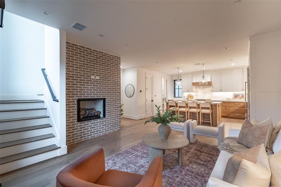 Living room with hardwood / wood-style flooring and a large fireplace