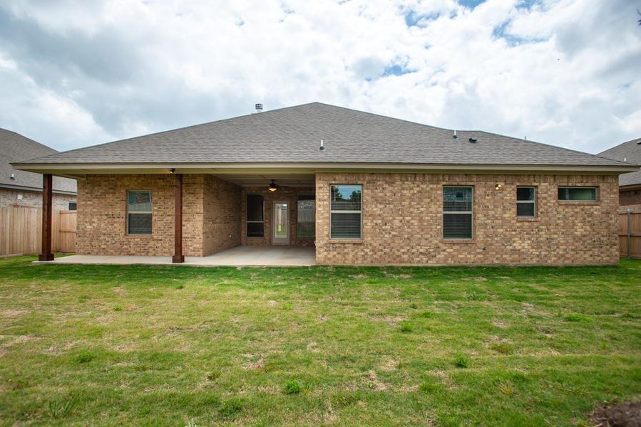 Back of house with fence, a patio area, and roof with shingles