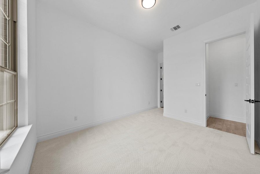 Bright and spacious bedroom located on the first floor with neutral finishes and an attached en-suite bath and closet.