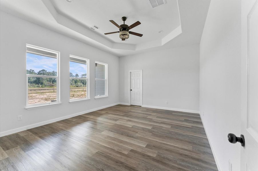 Oversized primary bedroom with high ceilings and multiple furniture walls—plenty of space for a king bed and seating. Oversized primary bedroom with high ceilings and multiple furniture walls—plenty of space for a king bed and seating.