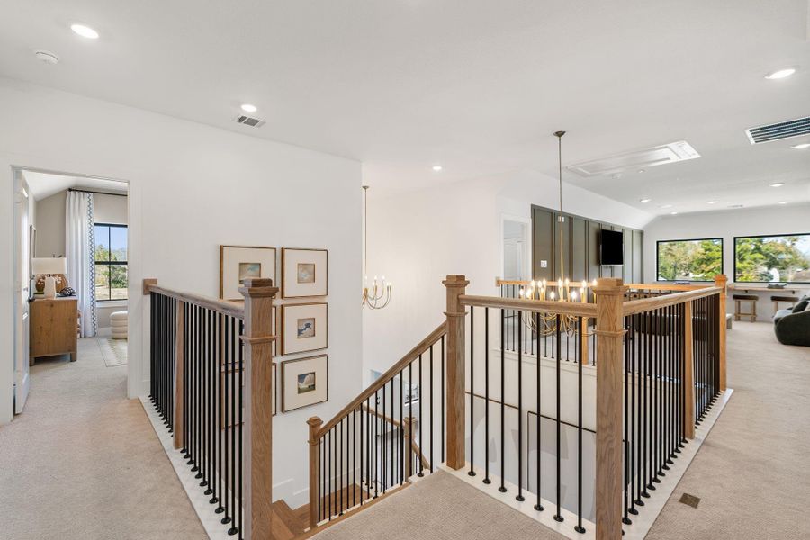 Overlooking the main level, this open and airy space is filled with natural light and provides ample room for a pool table, seating area, or home theater setup.