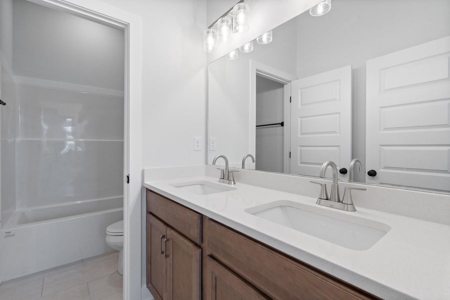 Dual vanity with undermount sinks, brushed nickel faucets, and light-toned countertops