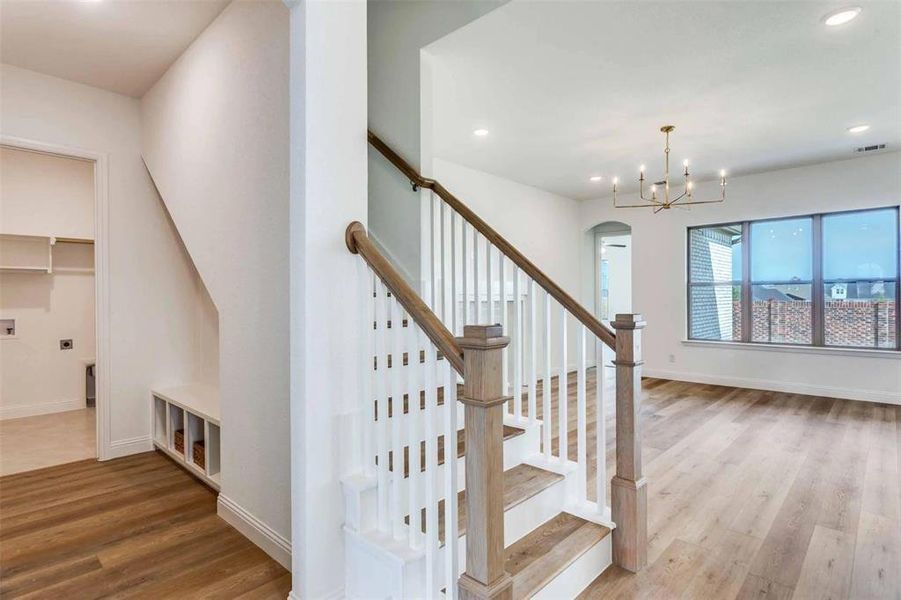 Stairway featuring wood finished floors, recessed lighting, arched walkways, and a chandelier Stairway featuring wood finished floors, recessed lighting, arched walkways, and a chandelier