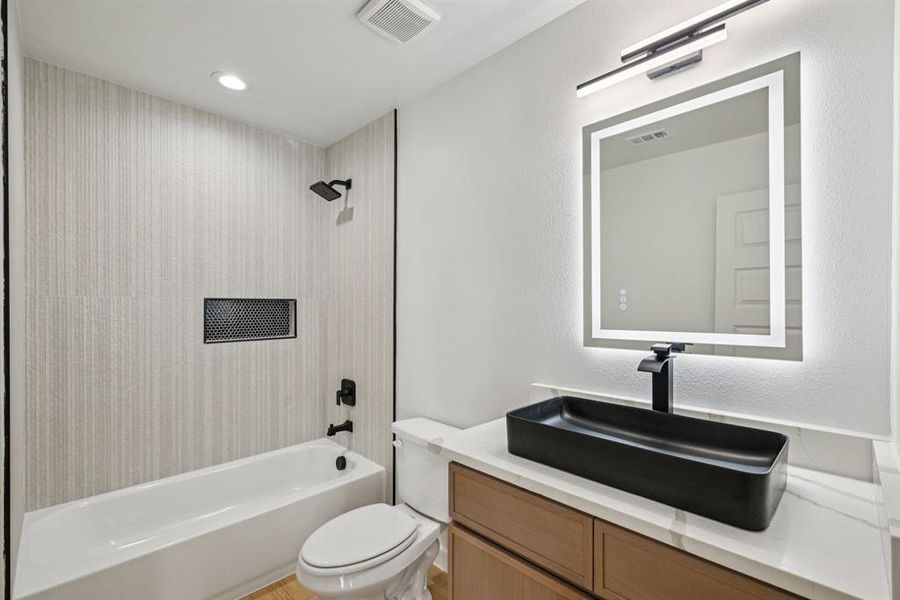 Bathroom with vanity, bathing tub / shower combination, and recessed lighting