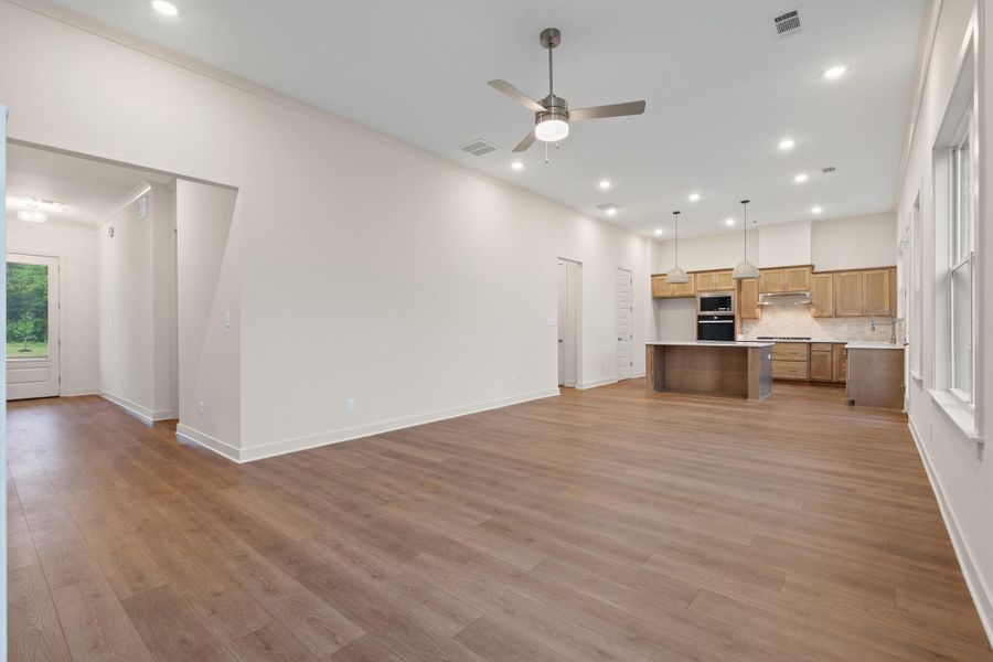 Open-concept living space featuring wood-finish flooring, recessed lighting, and a ceiling fan Open-concept living space featuring wood-finish flooring, recessed lighting, and a ceiling fan