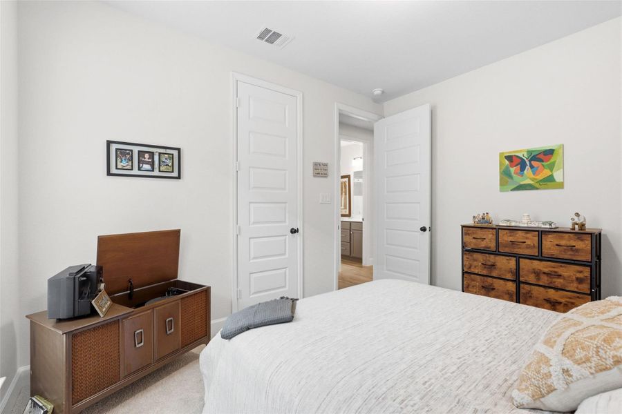 Light-filled bedroom featuring neutral wall tones, white trim, and light-colored carpeting