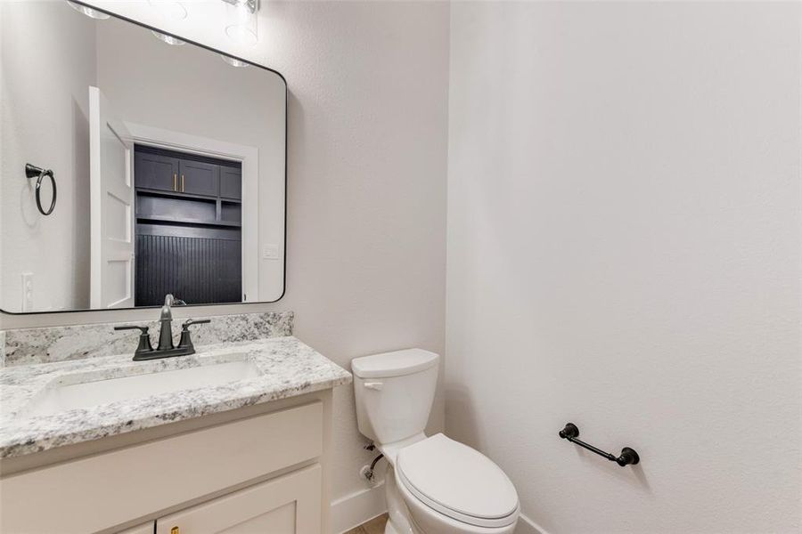 Half bathroom featuring vanity and toilet Half bathroom featuring vanity and toilet