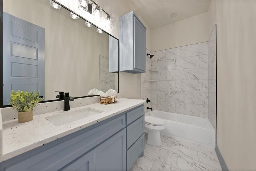 Bathroom with shower / bathtub combination, vanity, and light marble finish floors