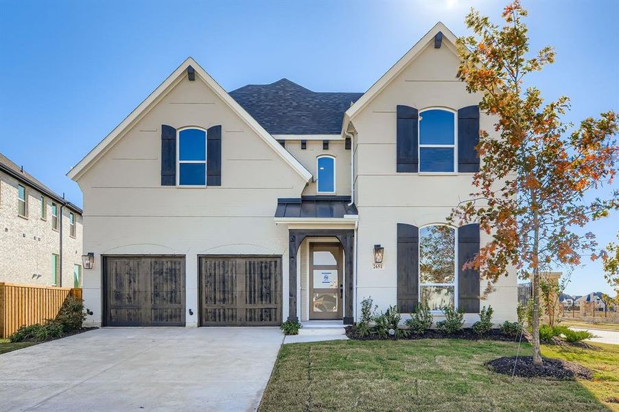 View of front of property with concrete driveway, a garage, stucco siding, a standing seam roof, and roof with shingles