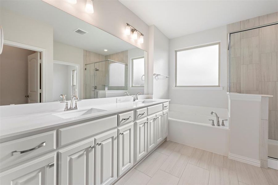 Full bathroom featuring double vanity, a bath, and a shower stall