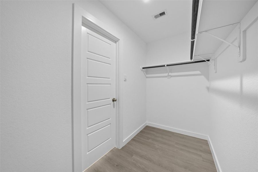 The primary suite's walk-in closet has ample storage for your daily wardrobes.