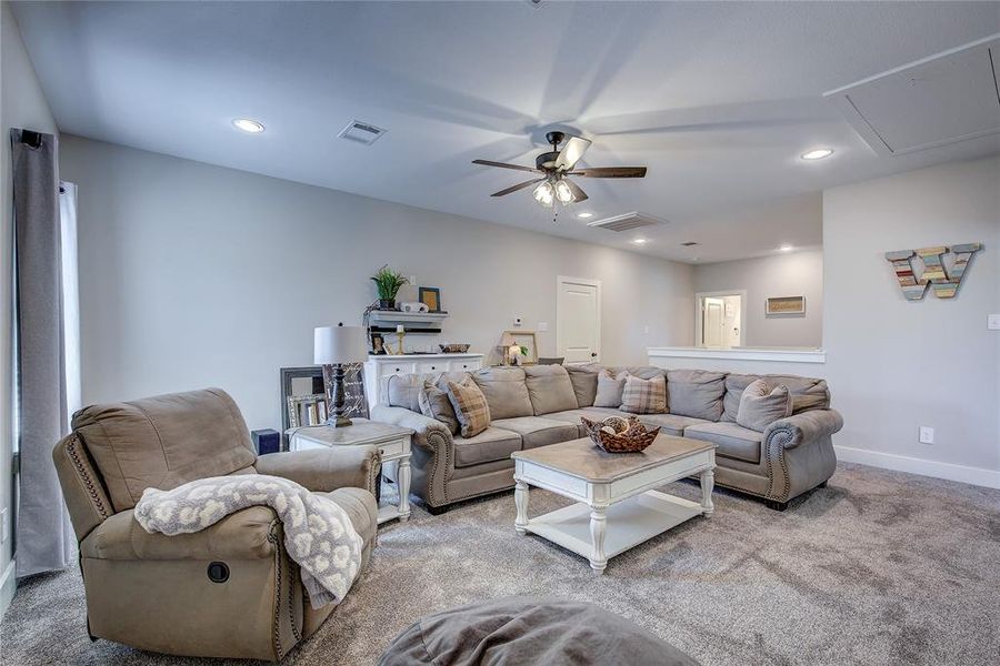 Carpeted living room featuring ceiling fan