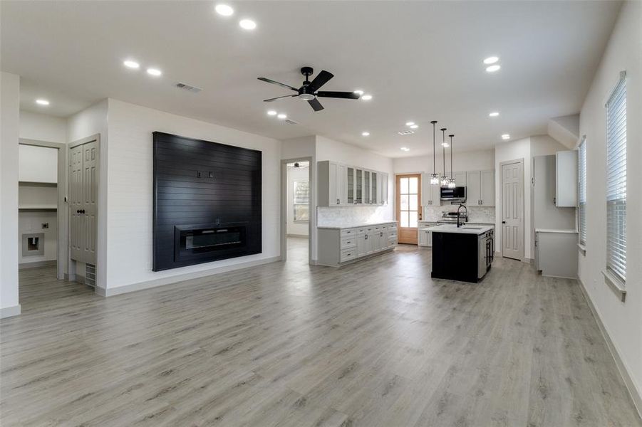 Unfurnished living room featuring recessed lighting, light wood-style flooring, and a ceiling fan Unfurnished living room featuring recessed lighting, light wood-style flooring, and a ceiling fan